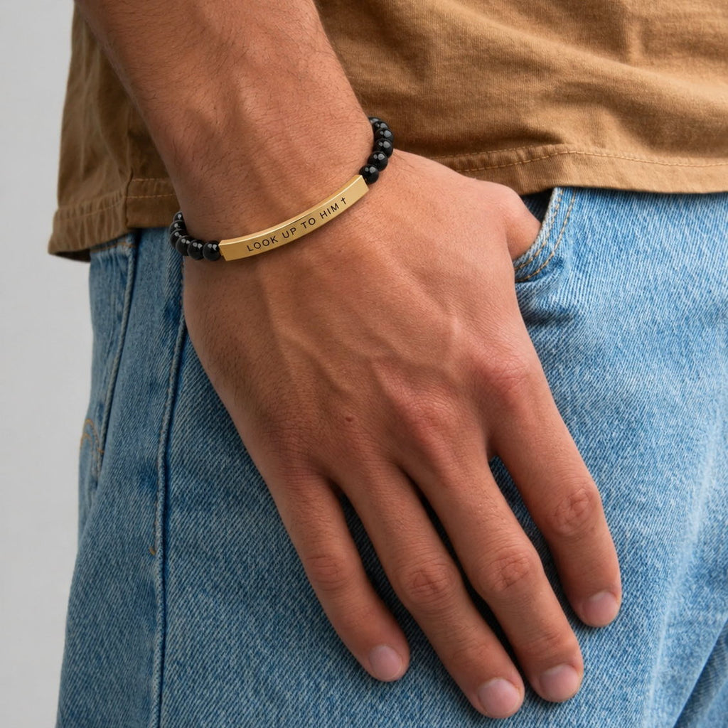 Hand in a pocket wearing the LOOK UP TO HIM beaded bracelet